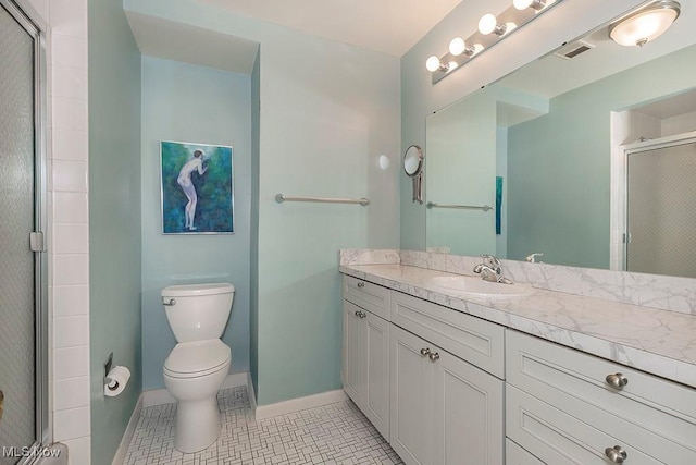 bathroom featuring tile patterned floors, toilet, vanity, and walk in shower