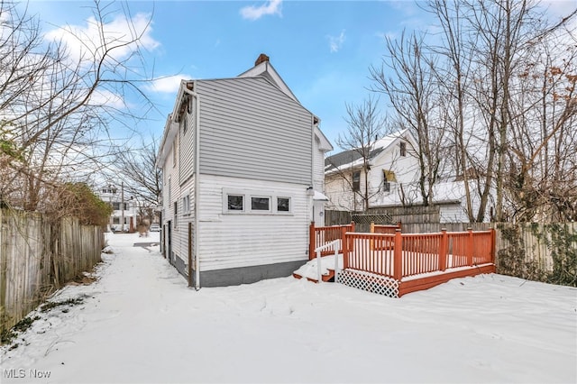 snow covered house featuring a deck