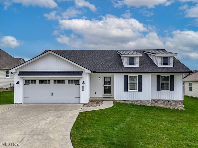921 Cabot Dr, Canal Fulton, OH 44614 - modern inspired farmhouse featuring a shingled roof, concrete driveway, a front yard, a garage, and board and batten siding