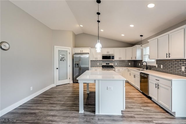 921 Cabot Dr, Canal Fulton, OH 44614 - kitchen with appliances with stainless steel finishes, vaulted ceiling, decorative backsplash, white cabinetry, and a sink