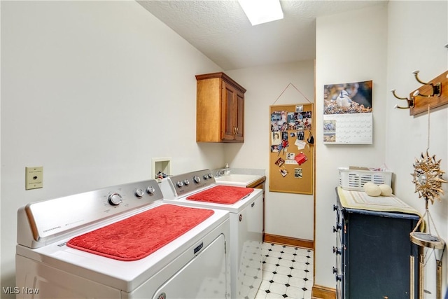 laundry area featuring cabinets, sink, separate washer and dryer, and a textured ceiling