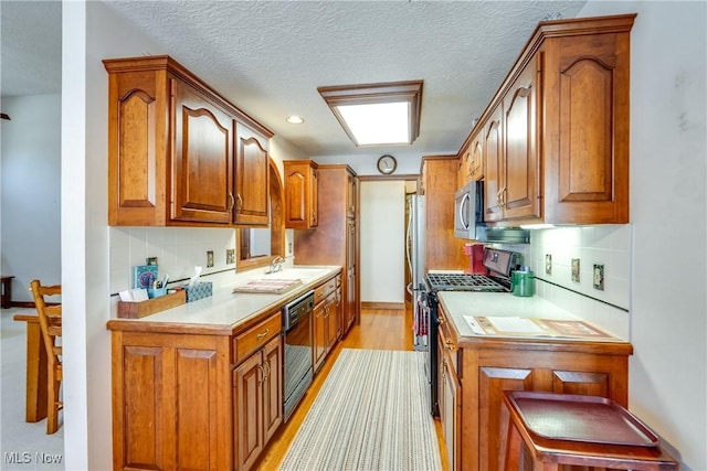 kitchen featuring light hardwood / wood-style floors, stainless steel appliances, tasteful backsplash, and sink