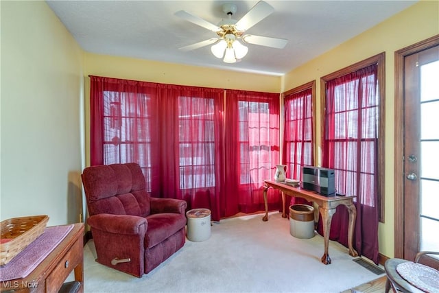 living area featuring ceiling fan and carpet floors