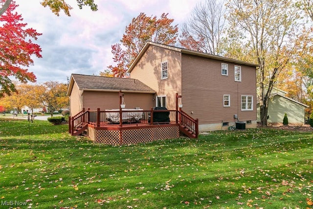 rear view of property featuring a deck, a yard, and cooling unit