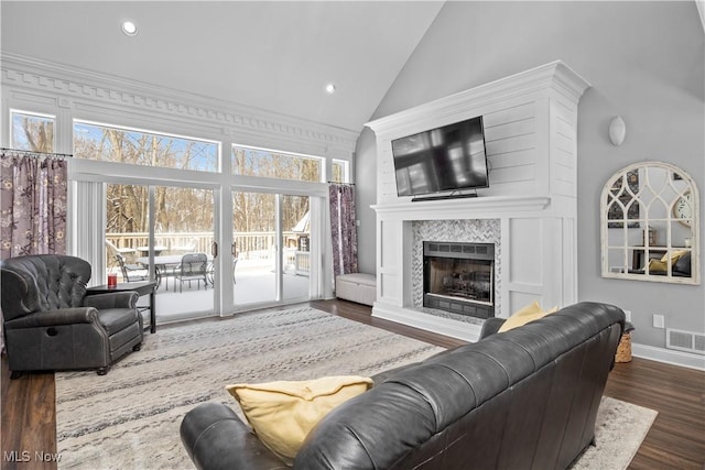 living room featuring a tile fireplace, high vaulted ceiling, and dark hardwood / wood-style floors