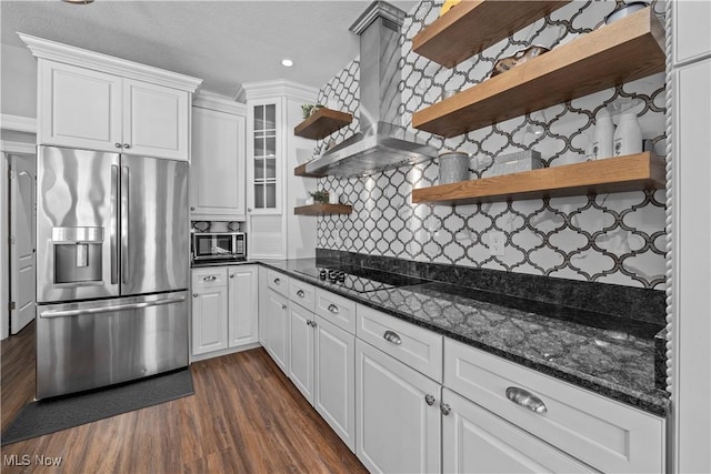 kitchen with appliances with stainless steel finishes, white cabinets, dark hardwood / wood-style floors, and range hood