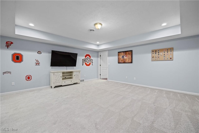 unfurnished living room featuring carpet and a tray ceiling