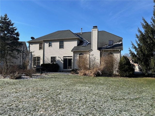 back of property featuring a yard and a chimney