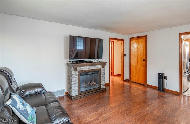 living room with dark hardwood / wood-style flooring and a fireplace