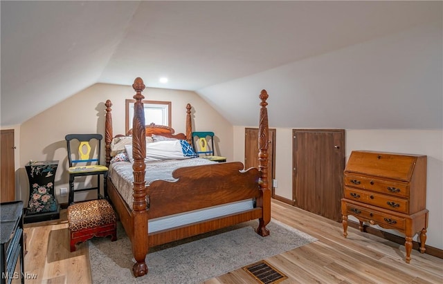 bedroom with light hardwood / wood-style floors and vaulted ceiling