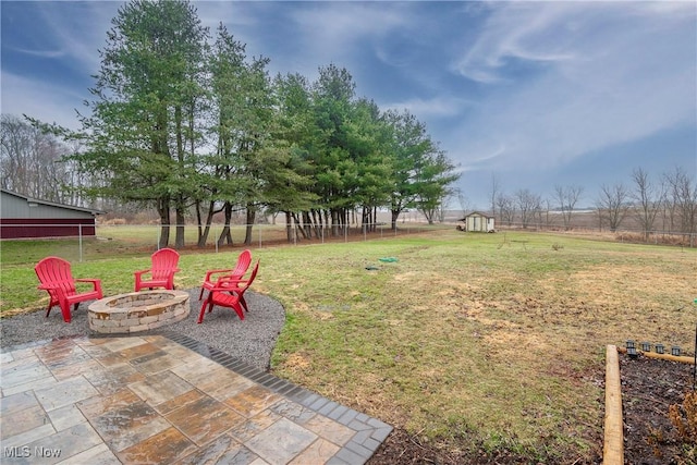 view of yard with a patio area, an outdoor fire pit, and a storage shed