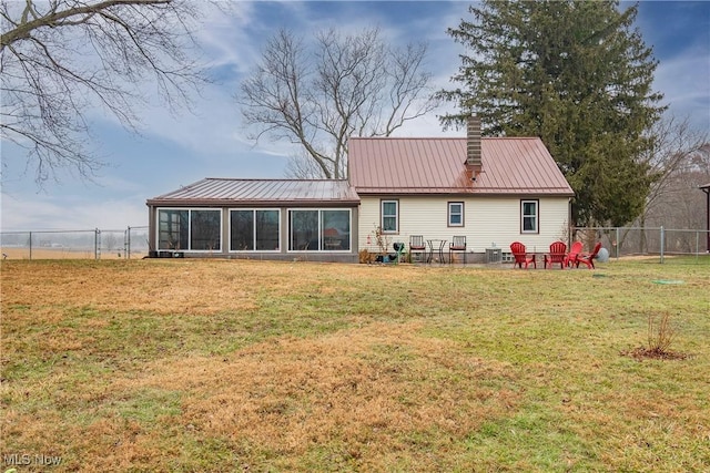 back of property with a yard and a sunroom