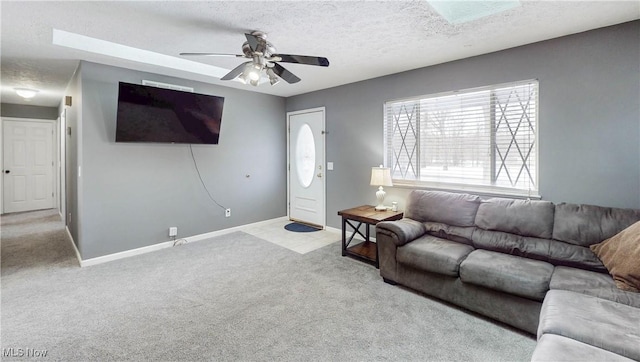 carpeted living room featuring ceiling fan and a textured ceiling