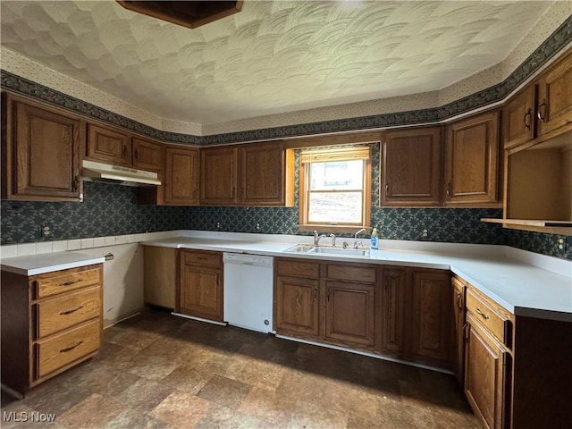 kitchen with white dishwasher, tasteful backsplash, a textured ceiling, and sink