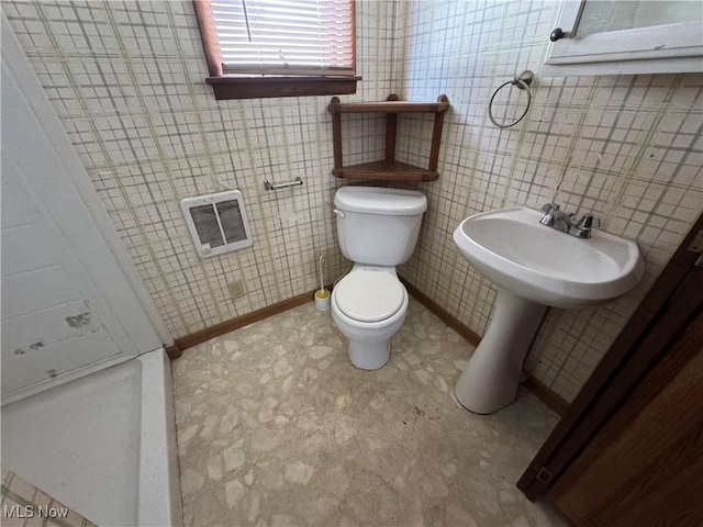 bathroom featuring heating unit and toilet