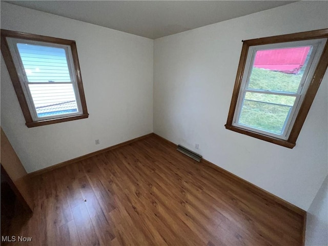 unfurnished room with hardwood / wood-style flooring