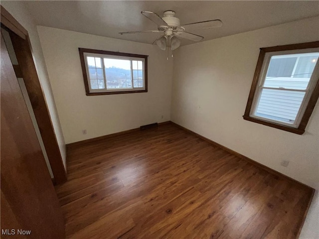 unfurnished bedroom featuring ceiling fan and dark hardwood / wood-style flooring