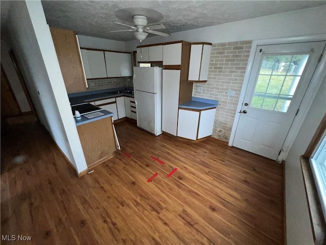 kitchen featuring white cabinetry, white fridge, and light wood-type flooring