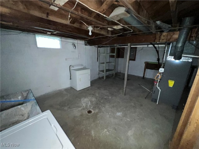 basement featuring heating unit and washer / dryer