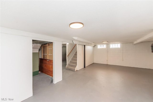 basement featuring stairs and concrete block wall