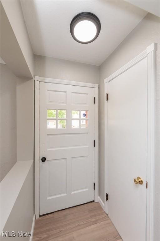 doorway to outside with light wood-style floors and baseboards