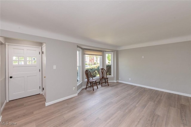foyer entrance with light wood-style floors and baseboards