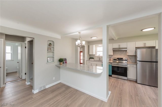 kitchen with stainless steel appliances, white cabinets, tasteful backsplash, under cabinet range hood, and light wood-style floors
