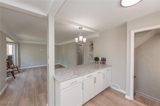 kitchen with light wood-style flooring, white cabinets, decorative light fixtures, a peninsula, and a chandelier