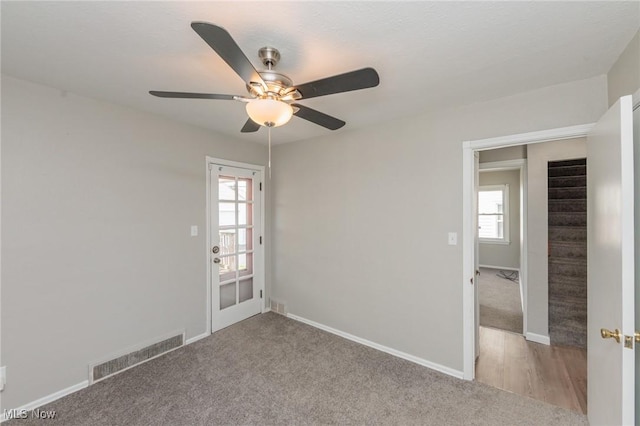 carpeted spare room with ceiling fan and baseboards