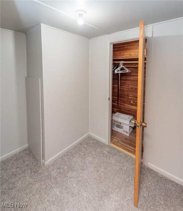 unfurnished bedroom with carpet floors, baseboards, and a closet