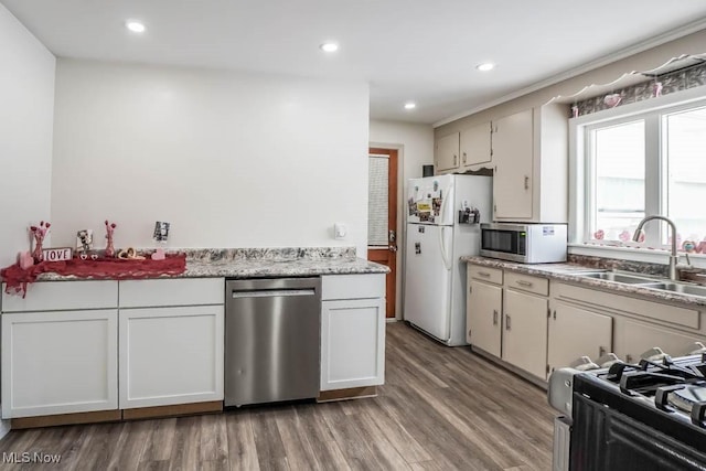 kitchen with sink, white cabinetry, stainless steel appliances, and light hardwood / wood-style flooring