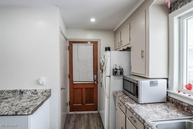 kitchen with white fridge and dark hardwood / wood-style flooring