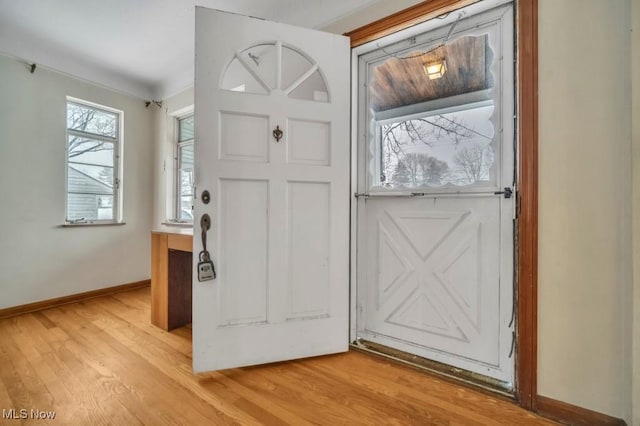 doorway with light wood finished floors and baseboards