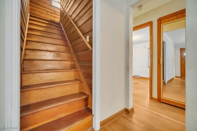 stairs featuring baseboards, visible vents, and wood finished floors