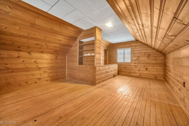 bonus room with wood ceiling, wood-type flooring, vaulted ceiling, and wooden walls