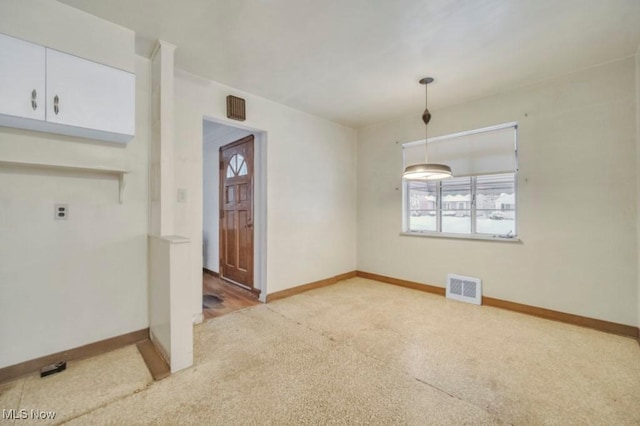 unfurnished dining area with visible vents, light carpet, and baseboards