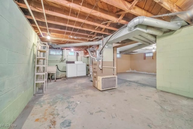 basement featuring concrete block wall and washing machine and dryer