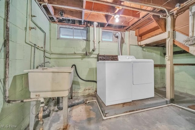 washroom with washing machine and dryer, laundry area, and a sink