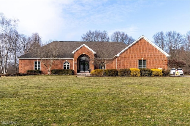 view of front of house with brick siding and a front lawn