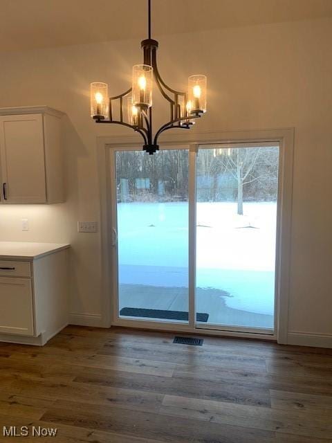 1775 Green Rd, Madison, OH 44057 - unfurnished dining area featuring dark wood-type flooring, a chandelier, and baseboards