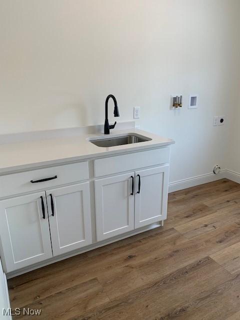 1775 Green Rd, Madison, OH 44057 - laundry room featuring washer hookup, hookup for an electric dryer, light wood finished floors, baseboards, and cabinet space