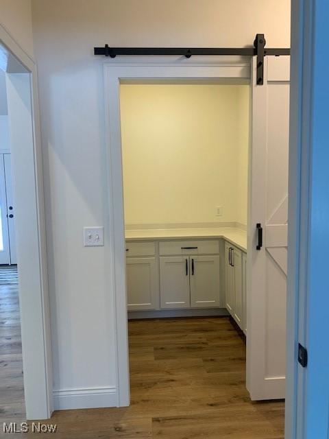 1775 Green Rd, Madison, OH 44057 - detailed view of wood finished floors, baseboards, and a barn door