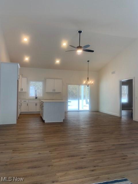 kitchen featuring dark wood-type flooring, a ceiling fan, white cabinets, and open floor plan