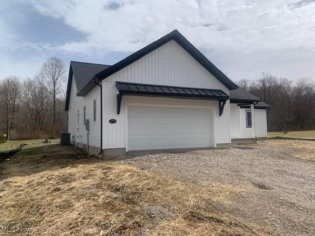 view of property exterior featuring a garage, metal roof, and a standing seam roof