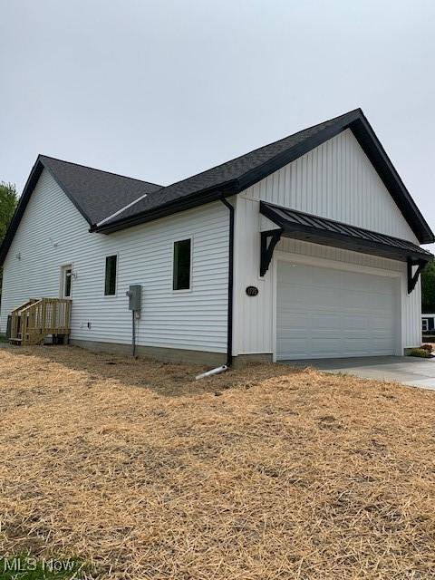 1775 Green Rd, Madison, OH 44057 - view of home's exterior featuring board and batten siding, driveway, and a shingled roof