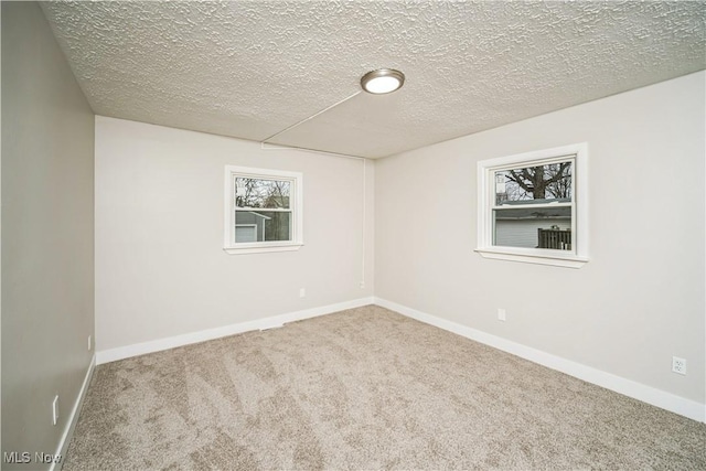 carpeted empty room with a textured ceiling