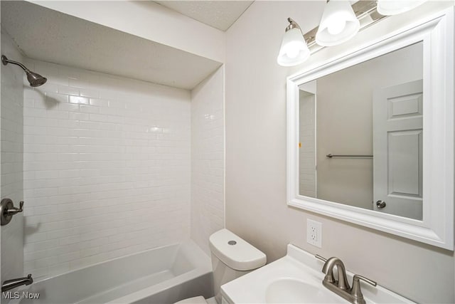 full bathroom with toilet, vanity, and tiled shower / bath