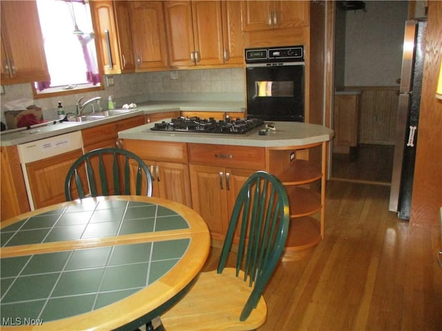 4520 E Wallings Rd, Broadview Heights, OH 44147 - kitchen with black oven, a sink, stainless steel gas stovetop, a kitchen island, and decorative backsplash