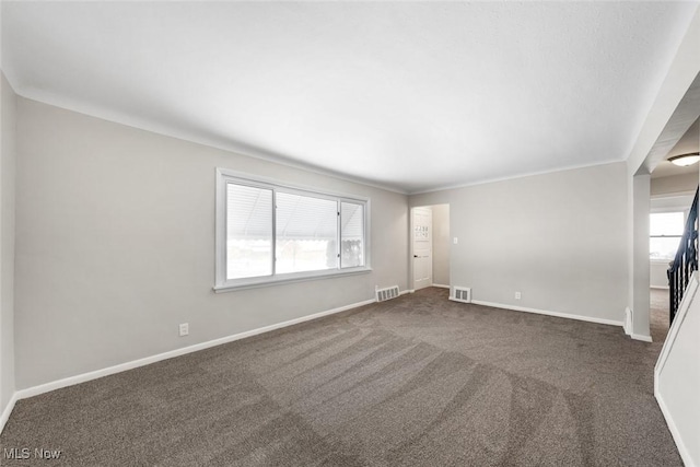 spare room with dark carpet and crown molding