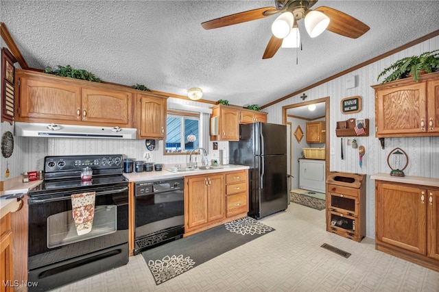 kitchen with a textured ceiling, black appliances, lofted ceiling, crown molding, and sink